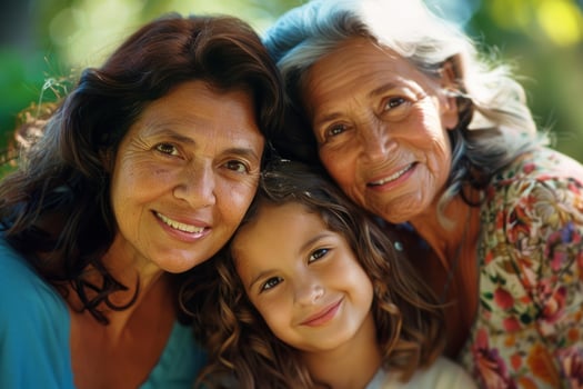 Grandmother, mother and granddaughter smiling together outdoors photo