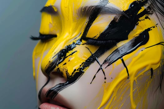 Woman with yellow and black paint dripping down face posing for beauty portrait photo