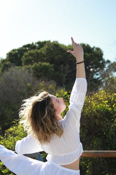 White-Clad Girl Makes Expressive Dance Moves Holding the Railing photo