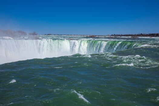 Witness the powerful Niagara Falls located in Ontario, Canada, showcasing the breathtaking waterfall cascading into the river below. photo
