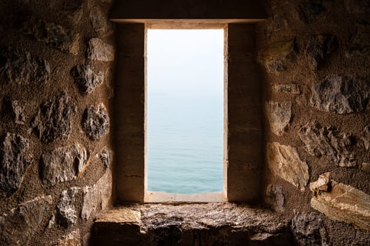 Medieval Stone Window Overlooking Tranquil Aqua Blue Sea on a Sunny Day photo