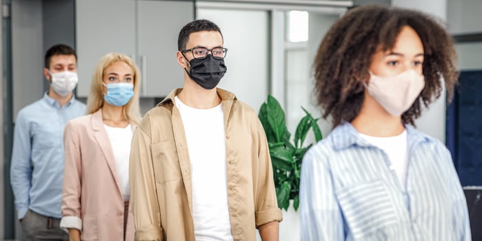 Queue to check temperature before work and new normal after lockdown and social distancing. Multiracial workers in protective masks near office entrance on job during coronavirus epidemic photo