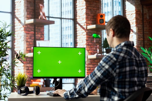 Freelancer in home office completing spreadsheets on mockup computer, entering data, calculating totals. Remotely working accountant analyzing figures on green screen PC, using spreadsheet software photo