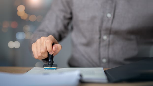 signing a business contract approval of contract documents confirmation or warranty certificate,approval stamp,Businessman validates and manages business documents and agreements photo