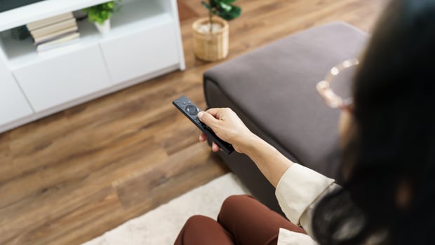 a woman holding a remote control while sitting on a couch photo