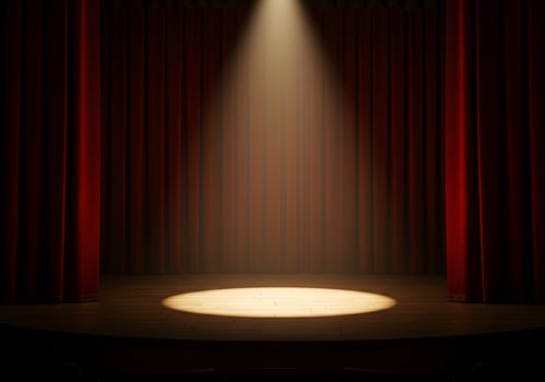 A stage with a spotlight and red curtains photo