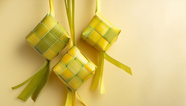 Three yellow and green ribbons tied to a yellow background photo