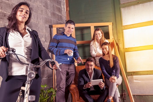 a group of young friendly successful business people in informal clothes posing for camera in a creative office photo
