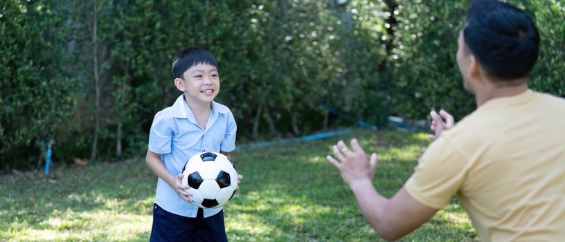 Wellness and happiness. Young boy playing soccer with father photo