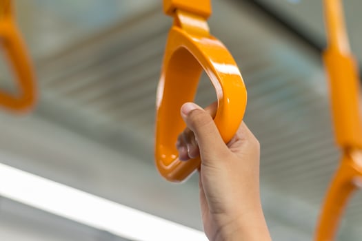Close up view of woman hand holding a handrail or hanging handle grip on the public transportation photo