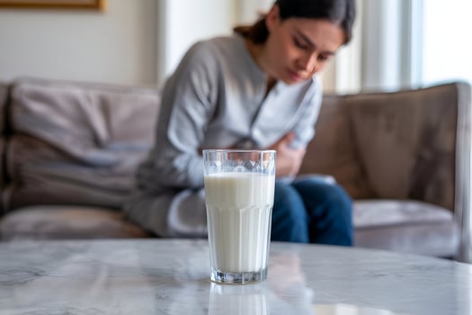 Glass of milk on marble with blurred person in background photo