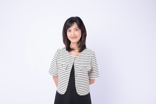 Southeast asian woman stands confidently with gentle smile wearing striped jacket and black dress perfect for advertising and lifestyle photo