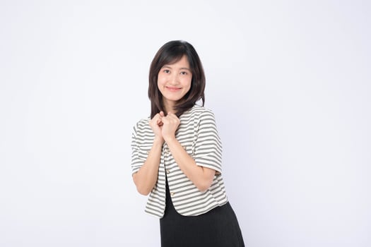 Southeast asian woman smiling warmly in striped jacket posing happily for advertising with clean white background and natural expression photo