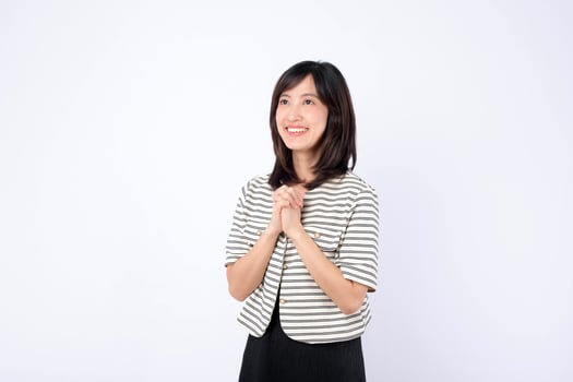 Southeast asian woman smiling happily with hands clasped in hopeful pose perfect for advertising and positive messaging campaigns photo