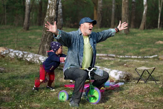 Grandfather and grandson are having fun playing with a bicycle in nature. photo