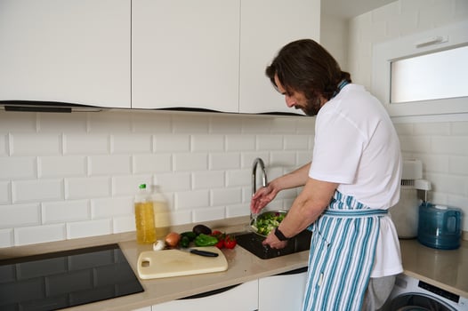 Man in Home Kitchen Preparing a Fresh Vegan Salad photo