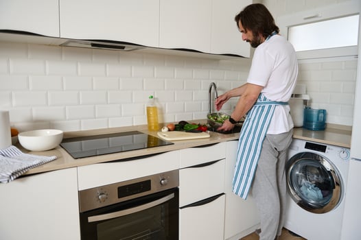 Man Preparing Healthy Salad in a Modern Kitchen With White Interior photo