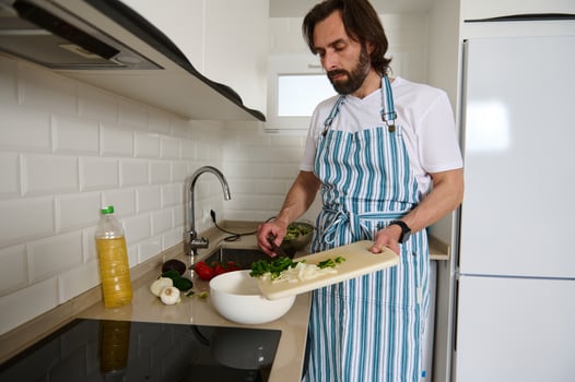 Man in Kitchen Preparing Healthy Salad Wearing a Striped Apron photo