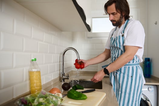 Man Preparing Healthy Vegan Salad in Modern Home Kitchen photo