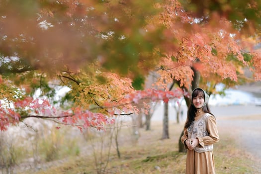 Southeast asian woman enjoys travel in autumn nature surrounded by colorful leaves creating peaceful and warm concept of outdoor exploration and seasonal beauty photo