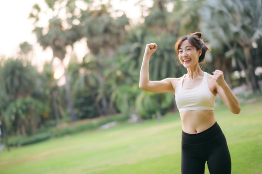 Southeast asian woman enjoying wellness and healthy lifestyle concept with exercise in outdoor park showing happiness and motivation photo