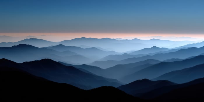 Majestic mountain range under twilight sky with soft haze photo
