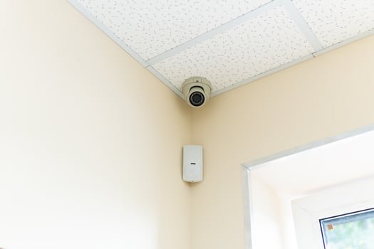 Security camera and motion detector installed on ceiling in room. photo