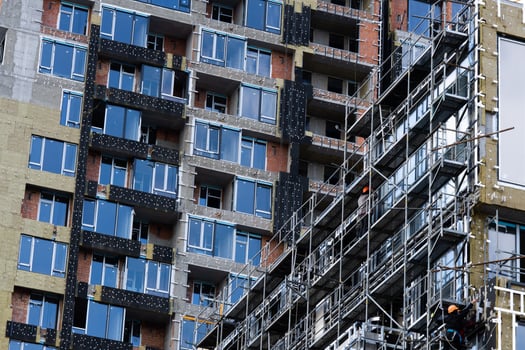 Construction of scaffolding and installation of glass facade panels against the backdrop of a new building photo