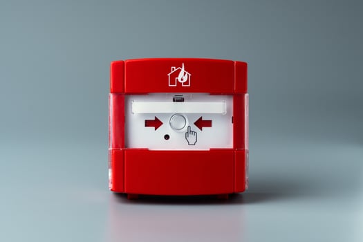 Red fire alarm on gray background. Close-up. photo
