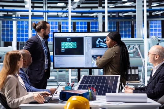 Factory management executives discuss solar panel technology and automation strategies, analyzing data to enhance sustainable manufacturing processes in advanced industrial facility photo