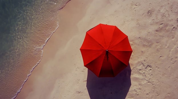 Red Umbrella on Sandy Beach with Person Walking Near Ocean photo