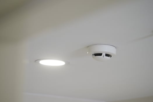 Smoke detector and ceiling light installed in modern room photo