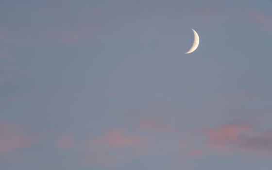 A crescent moon is seen in the sky photo
