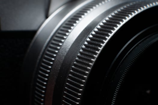 Macro photography of camera parts, featuring symmetry, texture and precision. Close-up of lens rings, ribbed surface photo