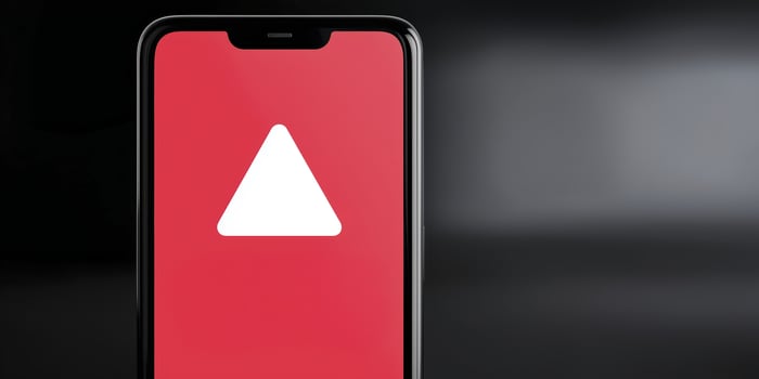 A smartphone with a red triangle on the screen photo