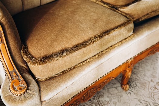 Luxurious vintage sofa with ornate wooden details and plush upholstery in a bright living room photo