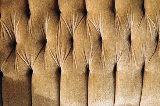 Elegant tufted fabric in warm tones enhances modern decor in a cozy living space photo