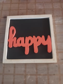 The Word HAPPY in Orange Letters on a Black Background with a White Frame photo