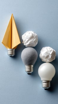 Three light bulbs with origami paper on them photo
