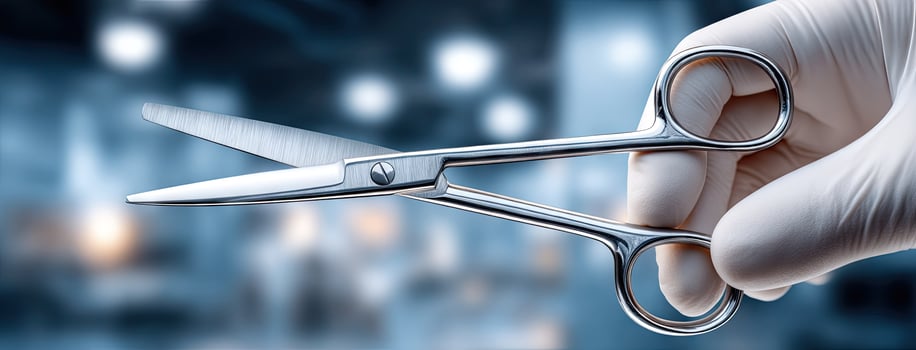 A person in a white glove holding a pair of scissors photo