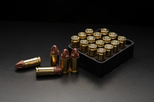 A set of 9mm ammunition rounds for pistols and PCC carbines, elegantly arranged on a shadowed backdrop. photo