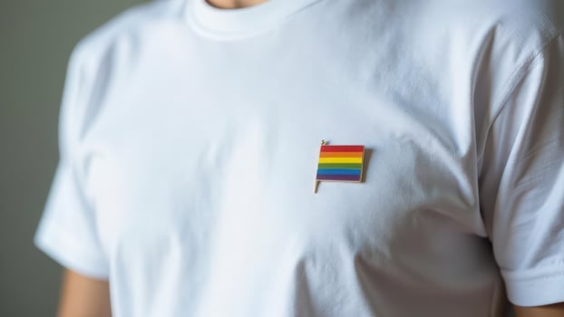 White t-shirt with rainbow flag pin celebrating lgbtq pride and diversity. LGBTQ Pride month . photo