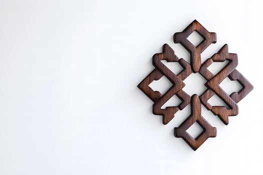 Intricately Carved Wooden Ornament Against a Minimalist Background Highlighting Unique Design Elements and Craftsmanship Showcased in Contemporary Decor photo