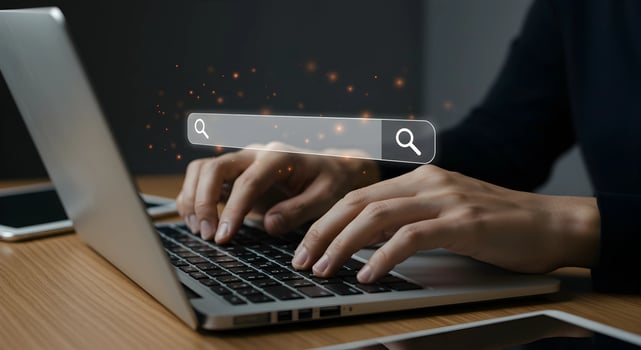 Hands Typing on Laptop with Search Bar Overlay photo