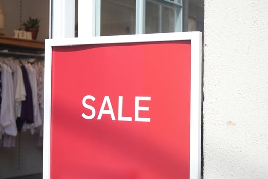 Sale sign outside retail store promoting discounts photo