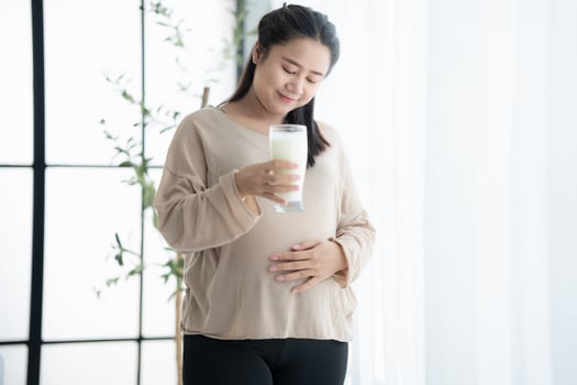 asian pregnant woman drinking milk in the morning photo