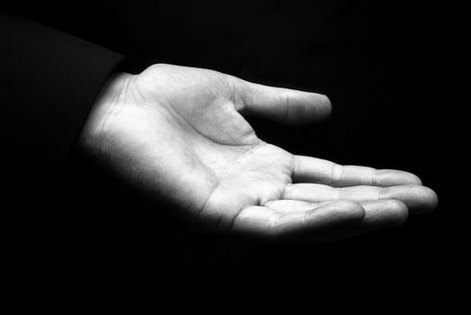 A close-up of an open hand against a dark background, symbolizing offering or waiting photo
