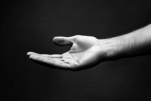 A close-up of an open hand against a dark background, symbolizing invitation or offering photo