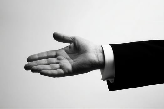 Elegant hand gesture in a formal suit, symbolizing invitation or greeting against a minimal background photo