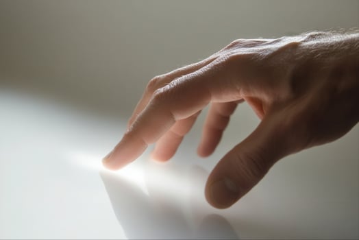 A close-up of a hand reaching towards a reflective surface, capturing a moment of curiosity photo